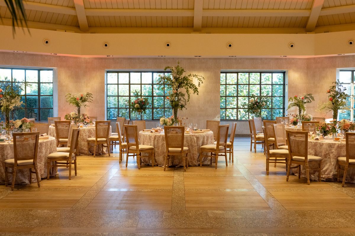 The Atrium hall set for the tea party, with pink toile tablecloths and flower centrepieces