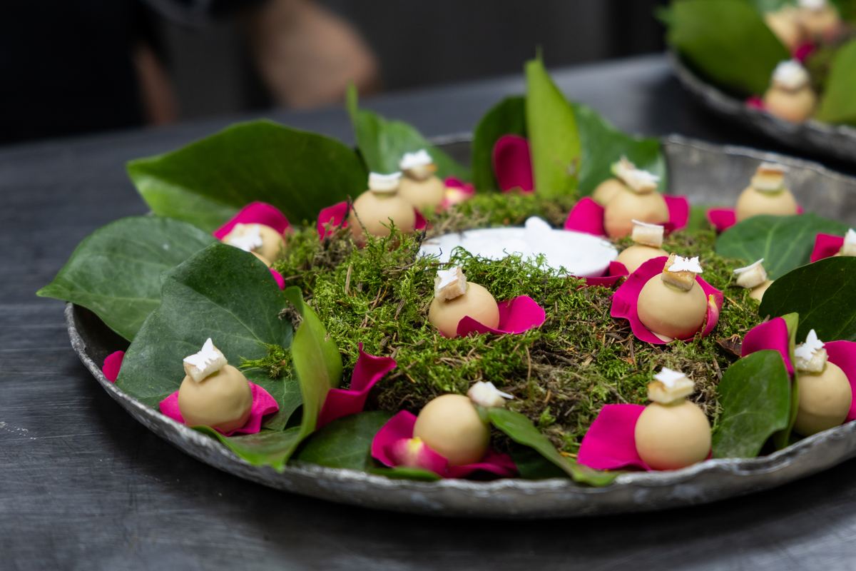 Plate of moss, leaves and petals prepared in the kitchen before service