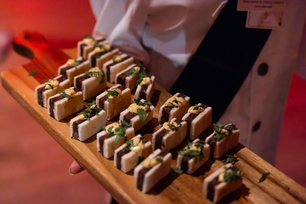 Tray of mini sandwiches served by a waiter