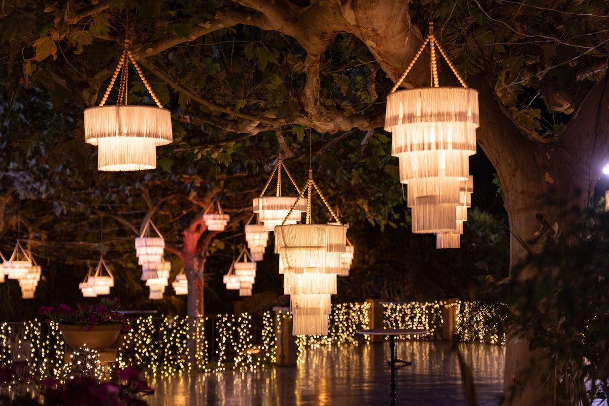 Crystal chandeliers hanging from the trees in the garden