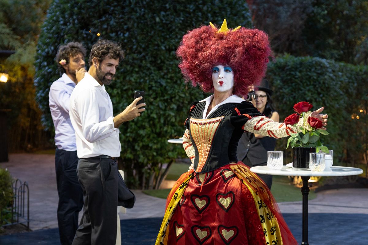 The Red Queen, in character, with guests in The Meadow garden