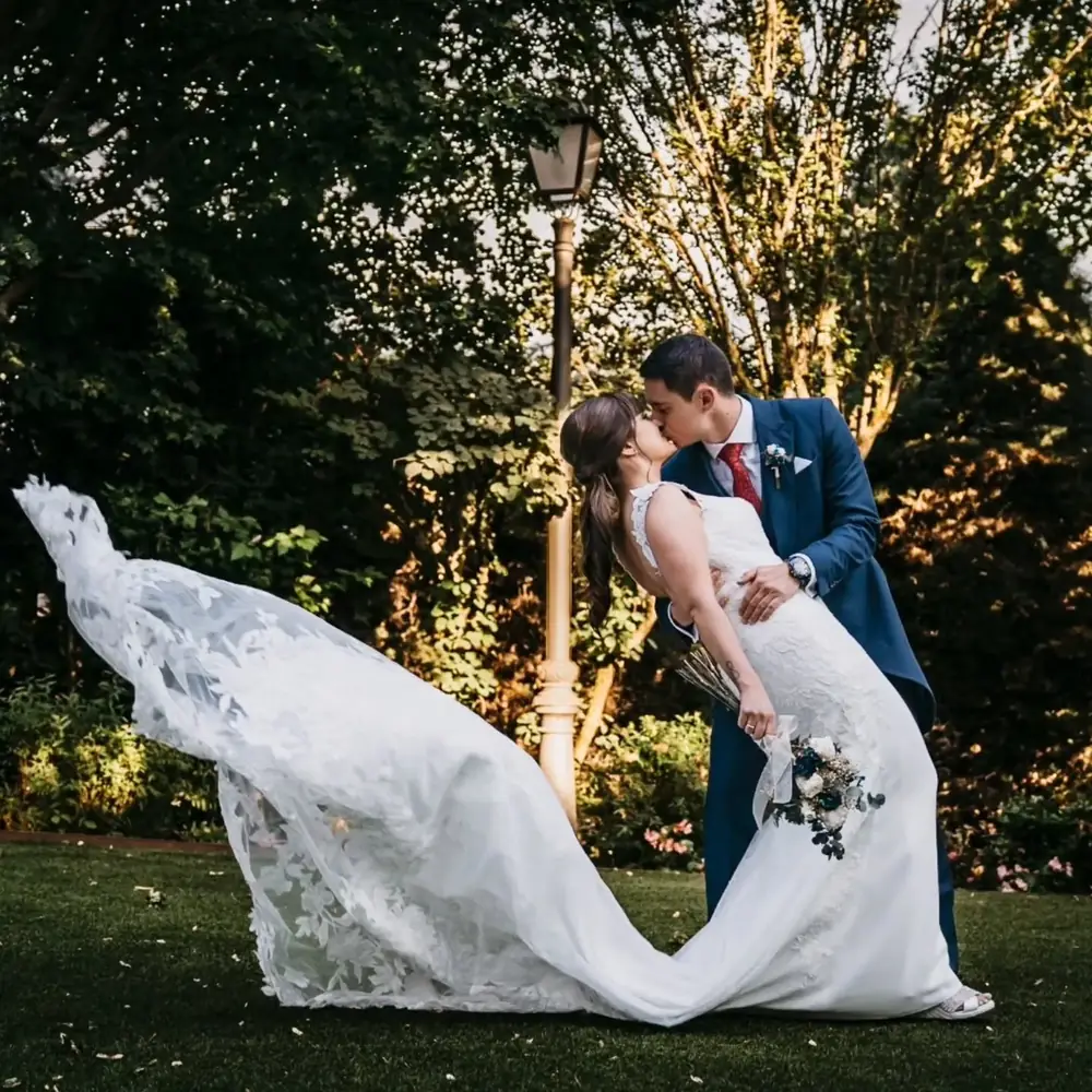 Novios besándose en el jardín al atardecer