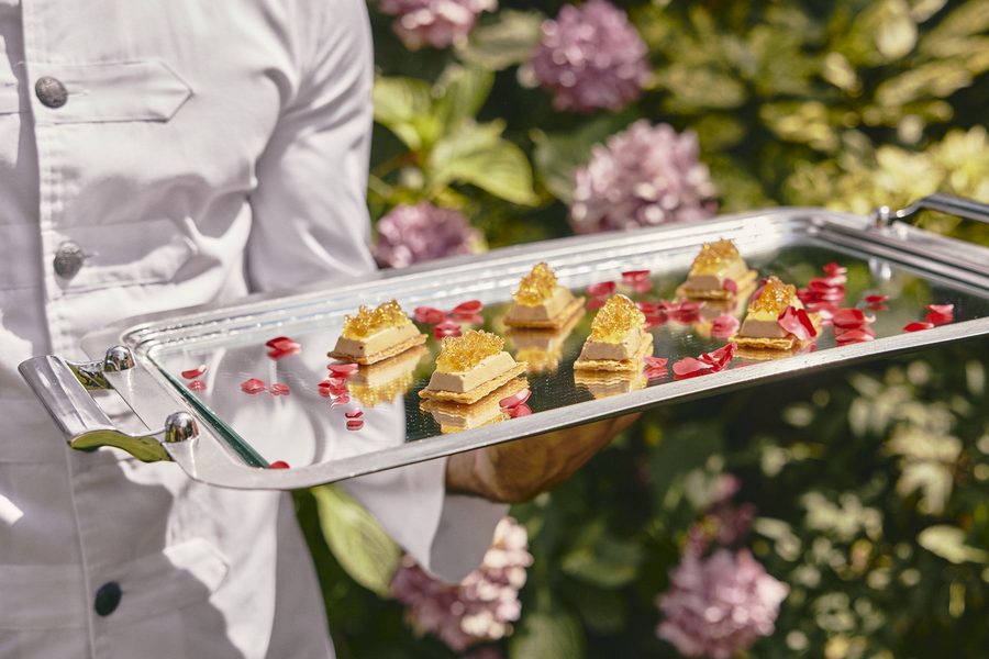 Bandeja de canapés de foie servida entre los jardines de la finca