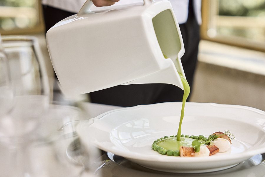 Crema verde servida al momento sobre el plato durante el servicio