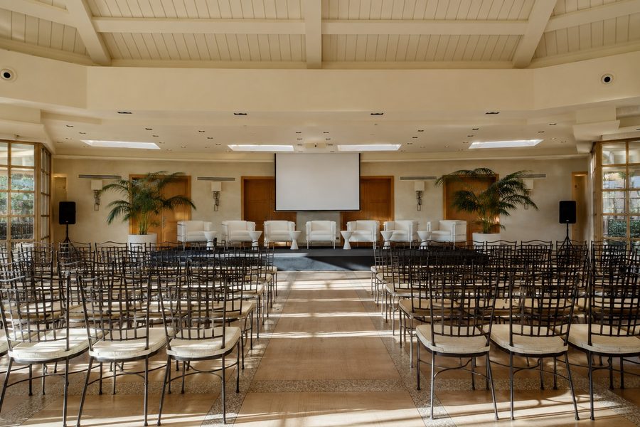 Sala montada en formato teatro con pantalla para una presentación de empresa