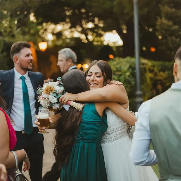 The bride hugs a guest in the garden